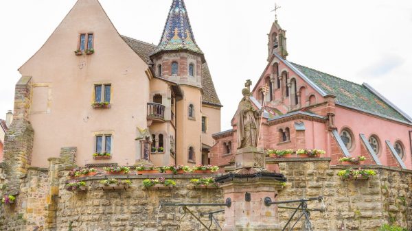 Der zentrale Platz mit dem Schloss, der Kapelle und dem Brunnen im Vordergrund.